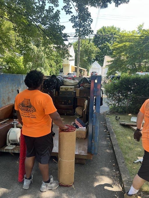 Grizzly Junk Pros two-person crew loading furniture into a truck on a residential job